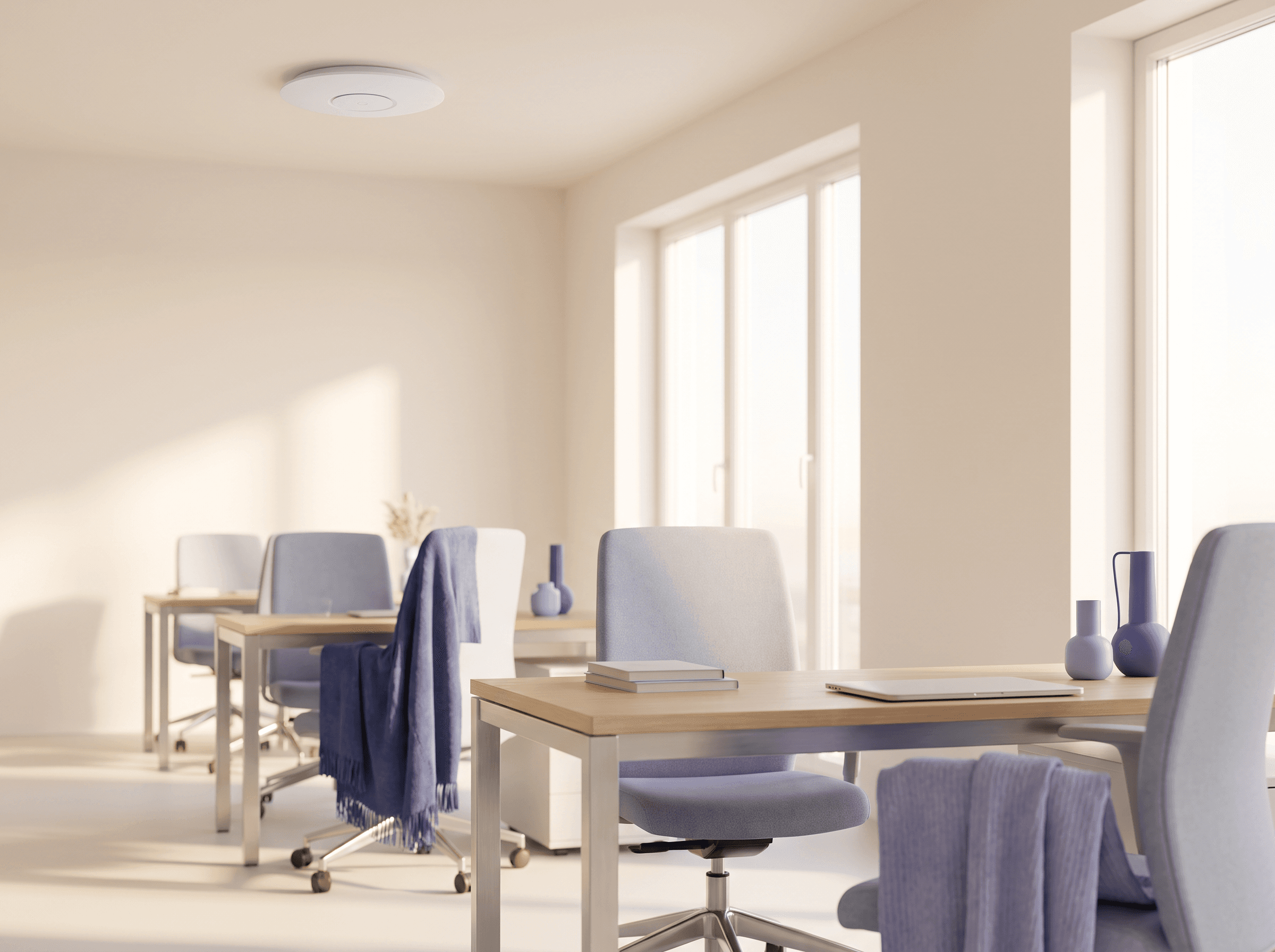 Bright modern office with a white wireless access point on the ceiling